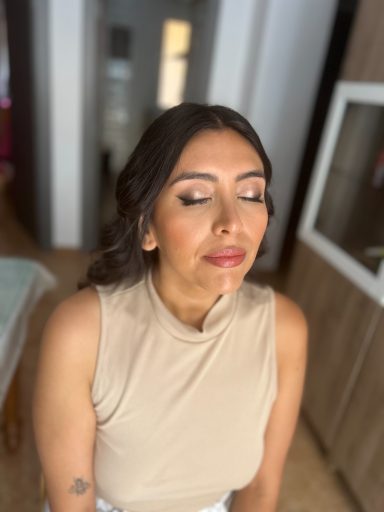 Invitada de boda con los ojos cerrados maquillada y peinada por maquilladora profesional en Málaga