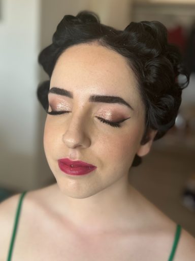 Invitada de boda con los ojos cerrados maquillada y peinada por maquilladora profesional en Málaga