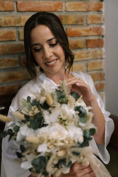 Novia maquillada y peinada por estilista en Málaga con su ramo de flores blancas